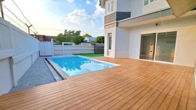 Modern backyard with swimming pool and wooden deck adjacent to the living space