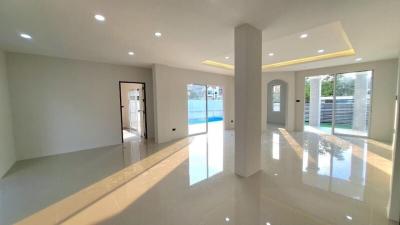 Spacious and modern living room with glossy floors leading to a pool area
