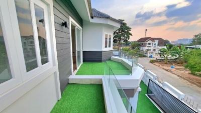 Modern home exterior with synthetic lawn and balcony