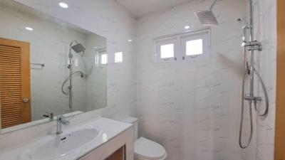 Modern bathroom with white marble tiles and stainless steel fixtures