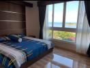 Bright bedroom with ocean view and hardwood floors