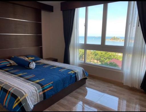 Bright bedroom with ocean view and hardwood floors