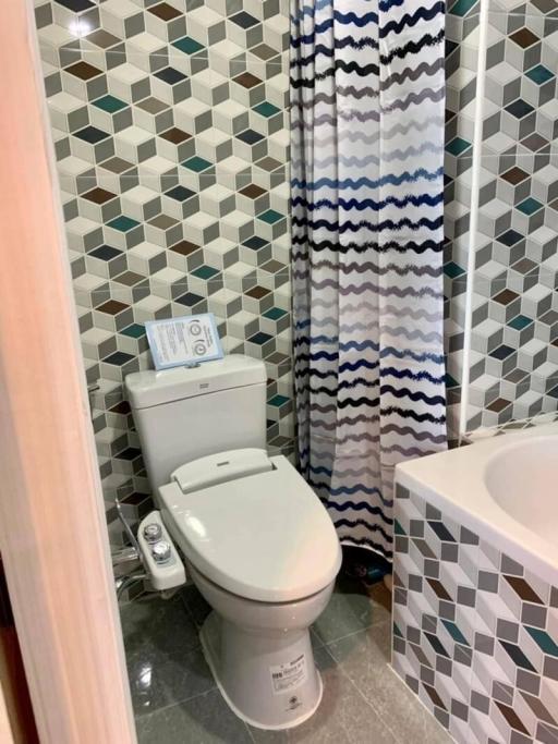 Modern bathroom with geometric tile pattern and bidet toilet