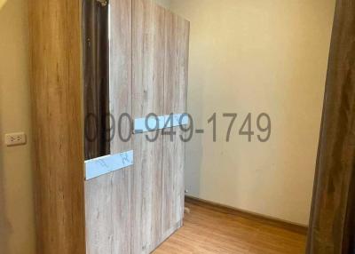 Compact bedroom with wooden wardrobe and air conditioning unit