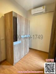 Compact bedroom with wooden wardrobe and air conditioning unit