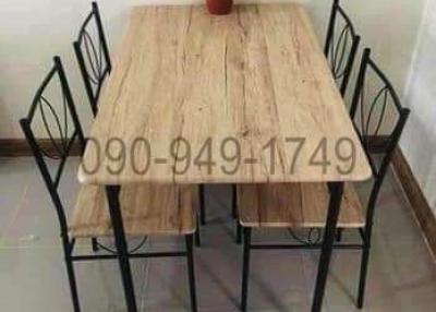 Dining table with chairs and a plant centerpiece in a simple dining area