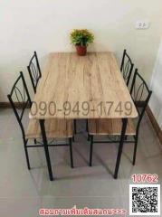 Dining table with chairs and a plant centerpiece in a simple dining area
