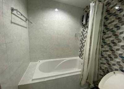 Modern bathroom with a bathtub and tiled walls