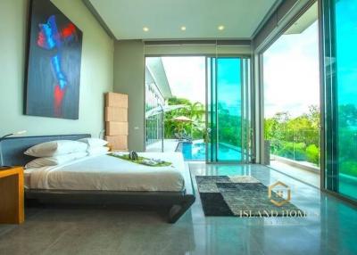 Spacious bedroom with large bed, floor-to-ceiling windows, and pool view