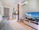 Modern living room with an open kitchen setup, featuring sleek furniture and contemporary design