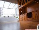 Spacious living room with high ceiling and wooden cabinetry