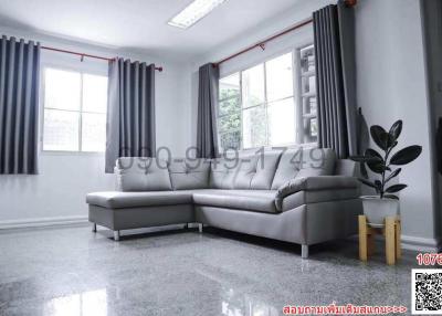 Spacious and modern living room interior with large windows, gray sectional sofa and glossy tiled floor