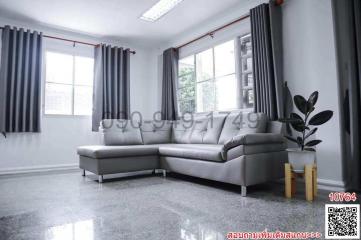 Spacious and modern living room interior with large windows, gray sectional sofa and glossy tiled floor