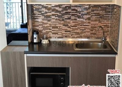 Modern kitchen with stainless steel appliances and mosaic backsplash