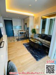Modern living room with kitchenette and ample lighting