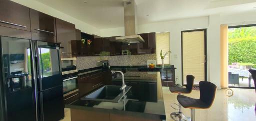 Modern kitchen with stainless steel appliances and garden view