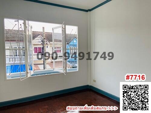 Empty bedroom with natural light and a view of neighboring buildings