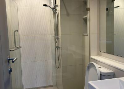 Modern bathroom interior with glass shower cubicle and white ceramic fixtures