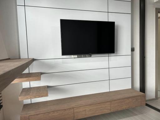 Modern living room with a flat-screen TV and wooden accents