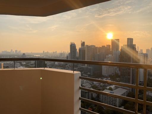 Sunset view from high-rise apartment balcony overlooking the city