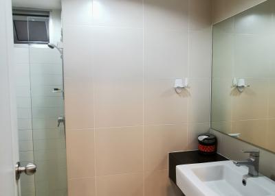 Modern bathroom with tiled walls and glass shower door