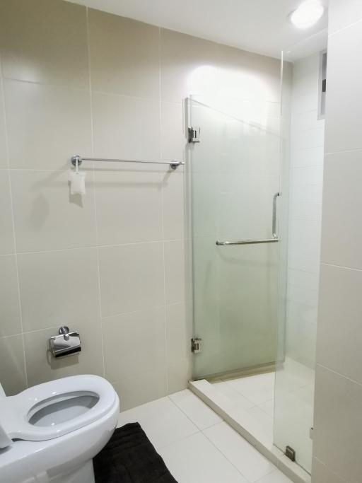 Modern bathroom with glass shower enclosure and white tiling