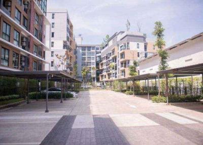 Modern apartment complex with pedestrian walkway and shaded parking areas