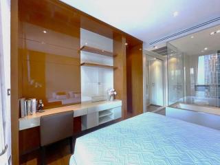 Modern bedroom with built-in wooden shelving and attached bathroom