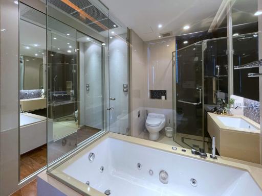 Modern bathroom interior with glass shower cabin, bathtub, and toilet