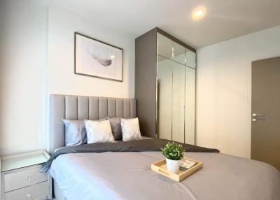 Modern bedroom with a large bed and mirrored wardrobe