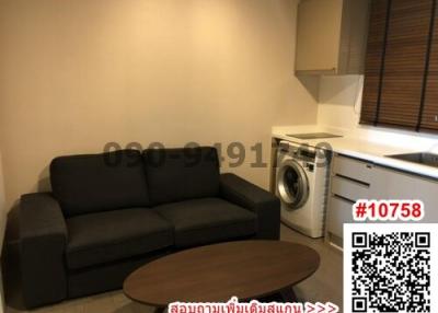 Compact living area with sofa, coffee table, and integrated laundry appliances