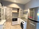 Modern kitchen with stainless steel appliances and patterned backsplash