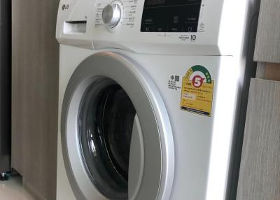 Modern white front-load washing machine in a clean laundry space