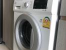 Modern white front-load washing machine in a clean laundry space