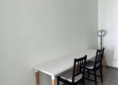 Minimalist dining area with a white table and black chairs