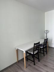 Minimalist dining area with a white table and black chairs