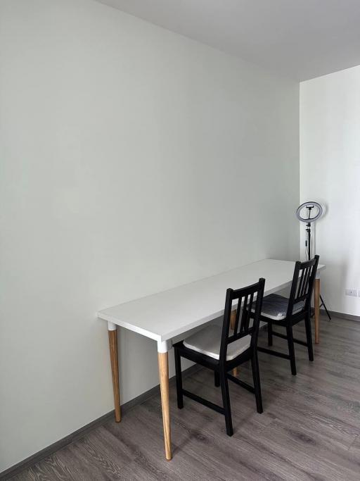 Minimalist dining area with a white table and black chairs