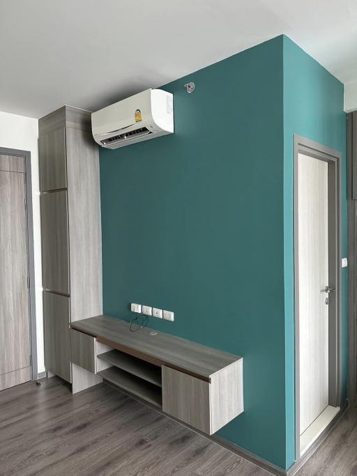 Modern entrance hall with teal accent wall and wood elements