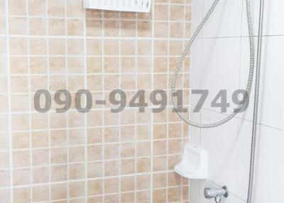 Modern bathroom with wall-mounted shower and tiled walls