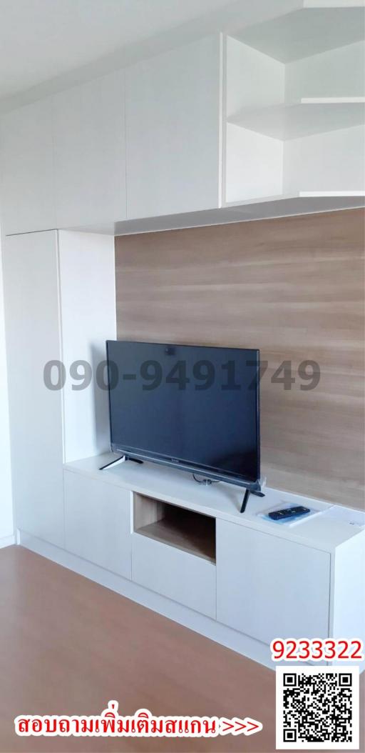 Bright and modern living room interior with mounted television and white storage cabinets