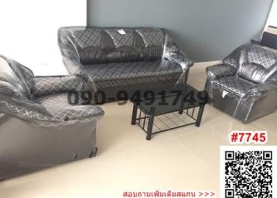 Furnished living room with plastic-covered sofas and a center table