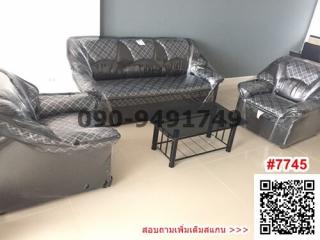 Furnished living room with plastic-covered sofas and a center table