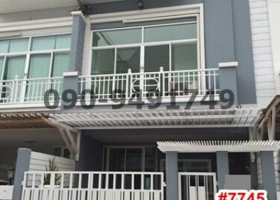 Modern multi-story residential building with balcony and secure entrance gate