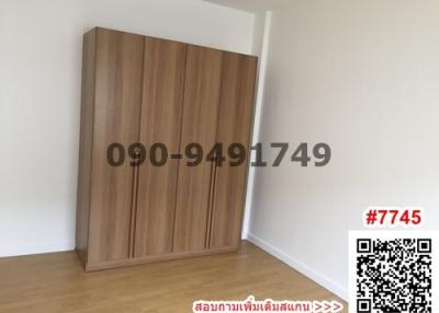Spacious bedroom with a large wooden wardrobe and bright white walls