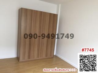 Spacious bedroom with a large wooden wardrobe and bright white walls