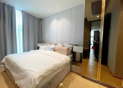 Modern bedroom with a large bed, mirrored wardrobe, and elegant decor