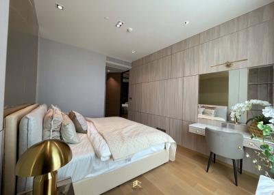 Modern bedroom with a comfortable bed, wooden paneling, and an integrated workspace