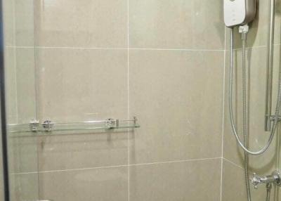 Beige tiled bathroom with shower and water heater