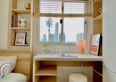 Cozy bedroom with a well-organized study area and city view