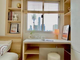 Cozy bedroom with a well-organized study area and city view